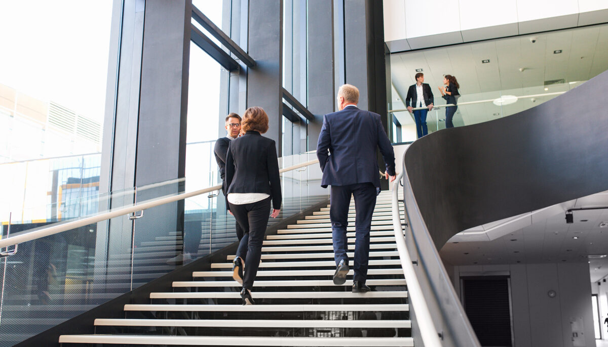 two work colleagues walking up staircase