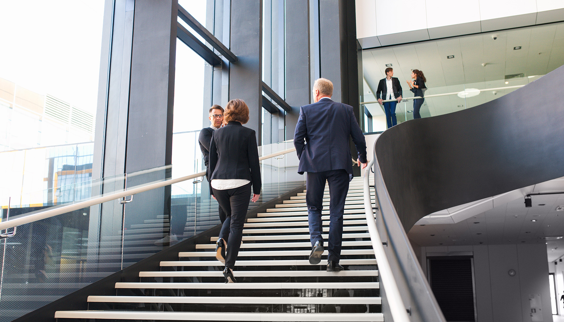 two work colleagues walking up staircase