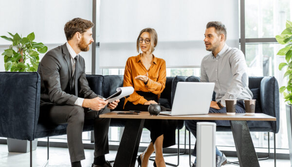 Young couple having an important discussion with financial consultant at the luxury bank office.