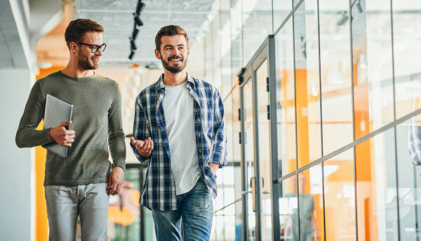 two men walking down a hall having a conversation