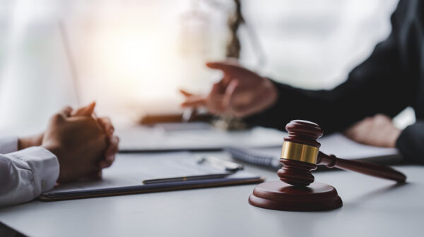 two people in a meeting with gavel in foreground